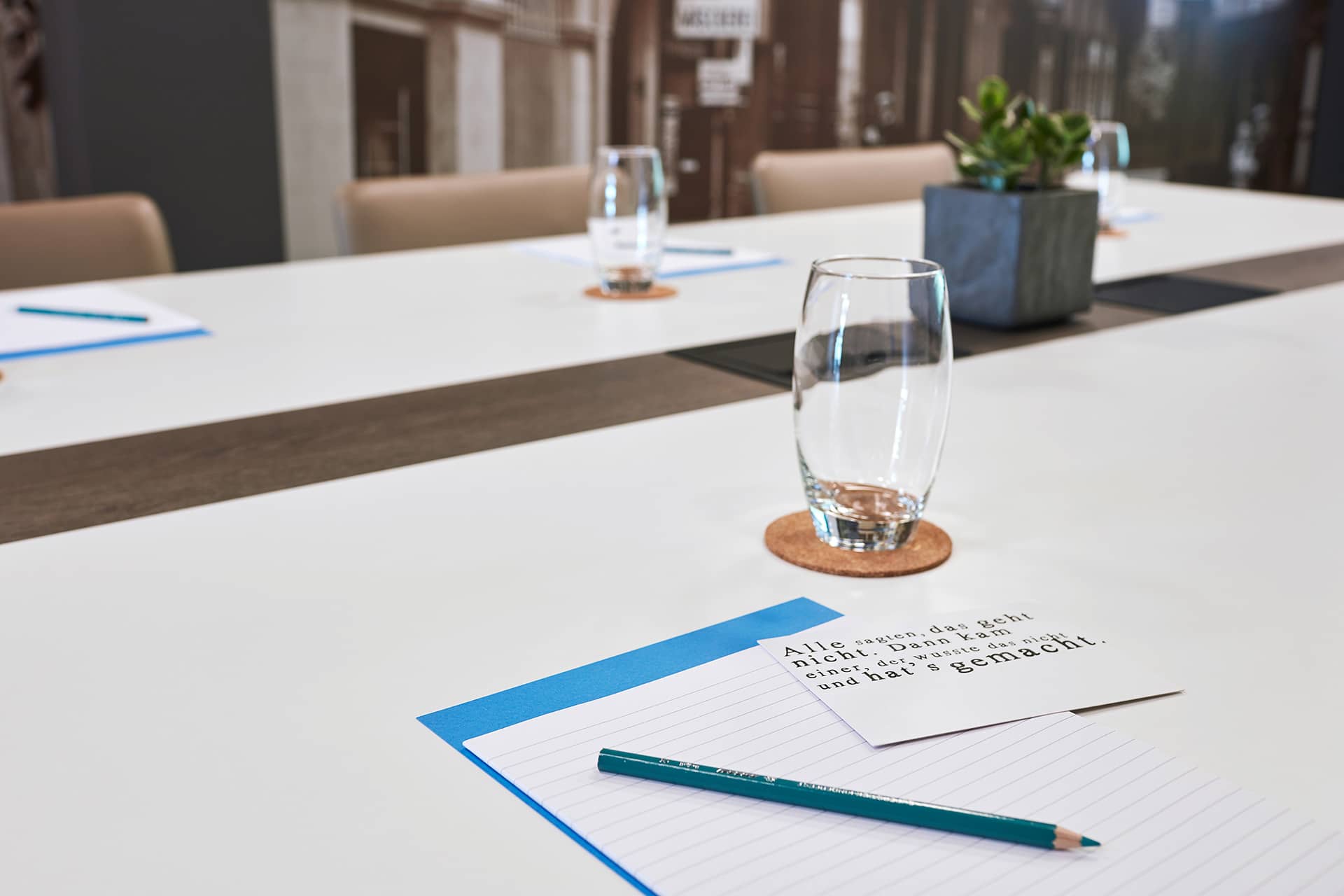 Arbeitsplatz mit Stift Zettel und Wasserglas